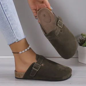 Detailed macro view of olive green suede clogs featuring adjustable buckle and cork sole