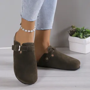 Close-up detail view of stylish dark brown suede clogs featuring an adjustable buckle strap