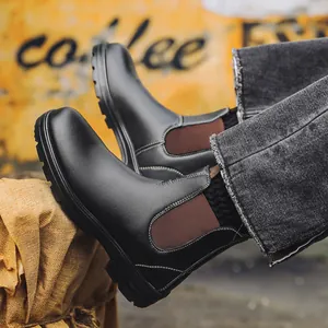 Gros plan de bottines Chelsea noires avec panneaux latéraux élastiques marron