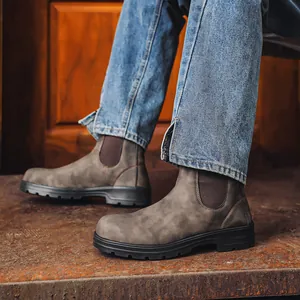 Vue détaillée de bottines Chelsea unisexes en cuir gris sur modèle avec semelles épaisses