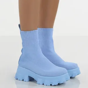 Detailopname van lichtblauwe gebreide soklaarzen met trendy platformzolen.