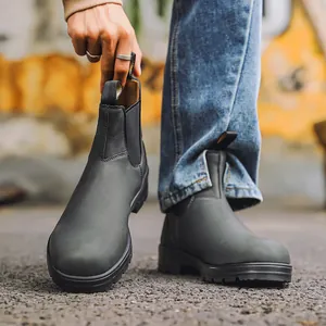 Vue détaillée des bottines Chelsea en cuir mat gris foncé dans un cadre urbain