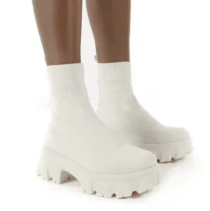 Detailweergave van witte gebreide soklaarzen met dikke platformzolen voor de wintermode