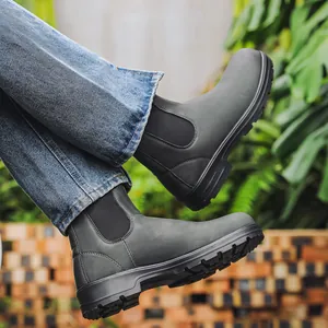 Gros plan détaillé de bottines Chelsea gris foncé portées avec un jean en denim bleu