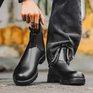 Détail de bottines Chelsea en cuir noir avec empiècements élastiques.