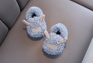 Detail van schattige lichtblauwe pluchen kindersloffen met oortjes en merklabel