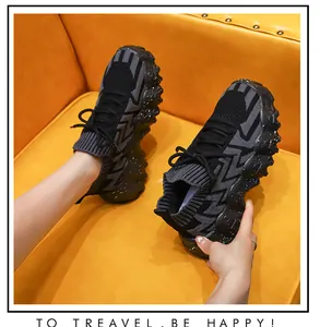 Vista detallada de zapatillas de punto negras y grises para mujer sobre amarillo