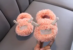 Detailed macro view of cute pink fuzzy baby slippers with soft plush fleece and 3D ears