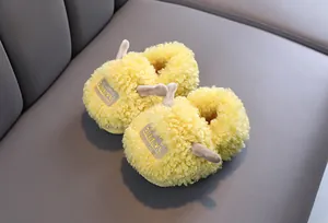 Macro weergave van schattige gele pluizige kindersloffen met warme pluche textuur