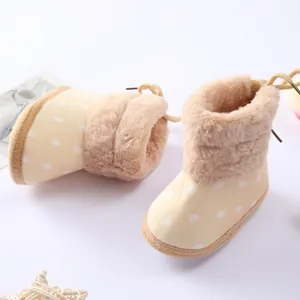 Detalle de botas de invierno para bebé con lunares, suela blanda y forro de peluche