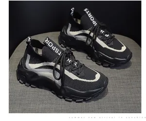 Macro view of black and white color-blocked flying woven sneakers with chunky soles