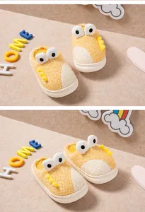 Vue détaillée de chaussons dinosaures jaunes pour enfants avec doublure chaude.