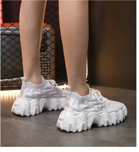 Primer plano de zapatillas tipo calcetín blancas para mujer con suela gruesa