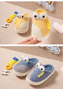 Gros plan de chaussons en peluche dinosaure mignons pour enfants en jaune et bleu.