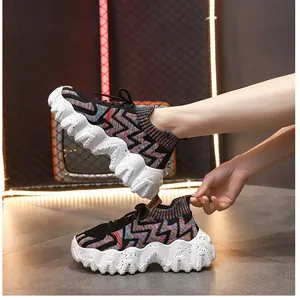 Primer plano de zapatillas tipo calcetín tejidas en colores con suelas de plataforma.