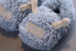 Detail van pluizige blauwe lammetjesstijl kinderwinterpantoffels met zachte warme voering