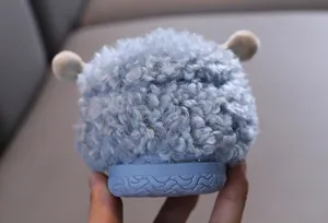 Close-up detail of cute light blue sheep-themed plush slippers with non-slip textured sole