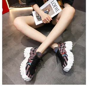 Vista en modelo de zapatillas de punto de colores con suelas de plataforma blancas.
