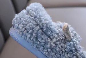 Close-up detail van de zachte blauwe krullende fleece-textuur van warme kindersloffen