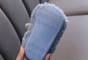 Detail van de antislip rubberen zool op blauwe pluche pantoffels voor kinderen