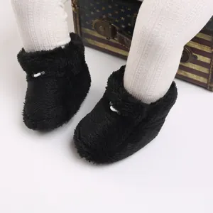 Détail rapproché de chaussons bébé en peluche noire douce pour la chaleur hivernale