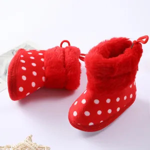 Primer plano de botas rojas de lunares para bebé con detalle de pelo sintético suave