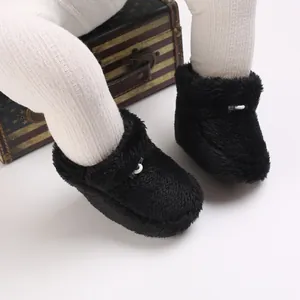 Détail de chaussures d'hiver douillettes en peluche noire pour bébé en fausse fourrure