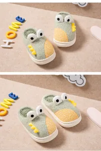 Gros plan de chaussons dinosaures mignons pour enfants avec peluche et semelle épaisse.