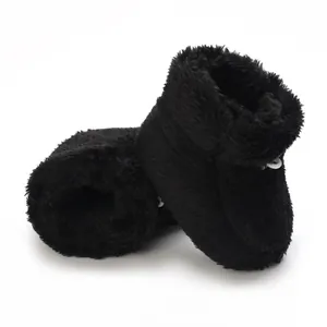 Gros plan sur des bottes d'hiver en peluche noire pour bébé avec boucle blanche détaille