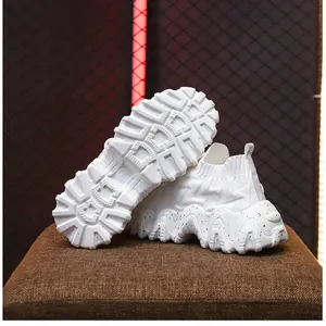 Vista detallada de zapatillas de punto blancas con suela gruesa antideslizante