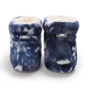 Détail de bottes en peluche pour bébé avec motif tie-dye et doublure polaire.