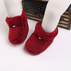 Gros plan de chaussons en peluche rouge pour bébé avec texture chaude en fausse fourrure