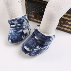 Gros plan de bottines bébé en peluche bleu tie-dye avec doublure douce pour 0-1 an
