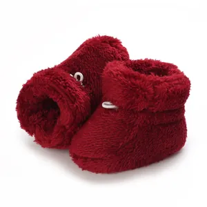 Vue détaillée des chaussons d'hiver pour bébé en peluche rouge foncé à texture douce