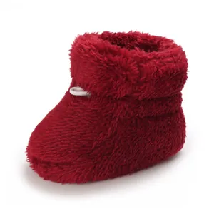 Gros plan d'un chausson de bébé rouge en peluche pour l'hiver, texture très douce