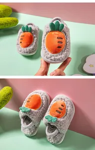 Détail de chaussons en peluche gris pour enfants avec motif carotte pour l'hiver