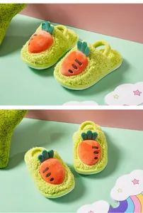Vue macro détaillée de chaussons en peluche verte pour enfants avec un motif carotte mignon.