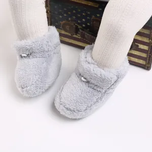 Gros plan de bottes d'hiver en peluche grise pour bébé avec fausse fourrure douce