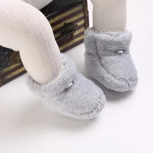 Gros plan détaillé des chaussures d'hiver en peluche grise pour bébé, texture douce