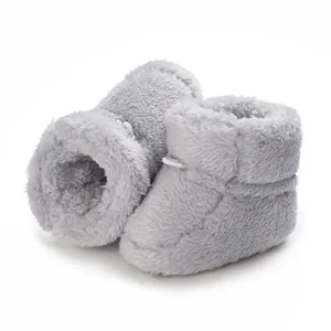 Vue détaillée de bottines bébé grises en peluche avec texture douce et doublure chaude d'hiver