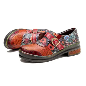 Close-up of vintage handmade leather loafers featuring vibrant ethnic floral print patterns.