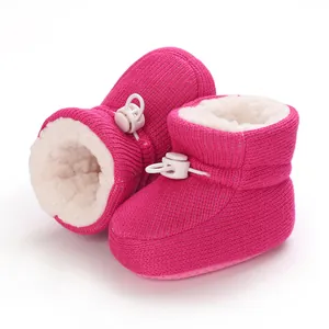 Dettaglio di stivaletti invernali in maglia rosa per neonati con fodera in pelliccia sintetica
