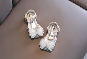 Vue détaillée de chaussures de princesse argentées pour filles avec un nœud en perles