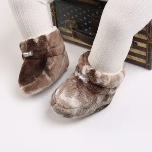 Gros plan sur des bottes bébé en peluche douillette avec semelles souples d'hiver.