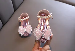 Gros plan de chaussures de princesse roses pour filles avec nœud en strass et perles