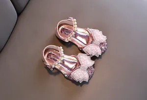 Détail en gros plan de chaussures de princesse roses pailletées avec nœud perlé