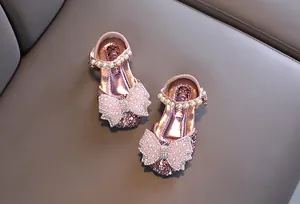 Détail de chaussures de princesse roses pour filles avec paillettes et nœud perlé