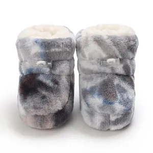 Gros plan sur des bottes d'hiver pour bébé en peluche avec motif tie-dye et doublure douce