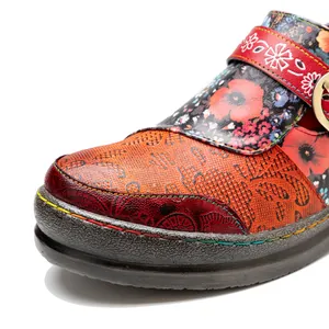 Close-up of vintage floral genuine leather flat shoes with handmade color-rubbed texture.