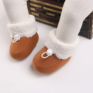 Gros plan de bottines d'hiver marron pour bébé avec doublure en polaire blanche.